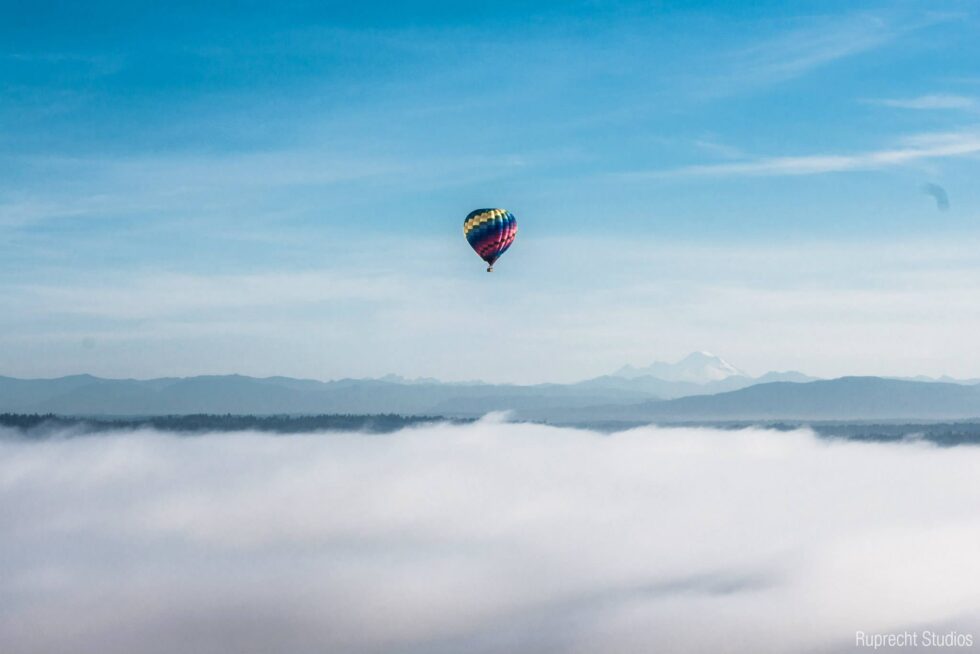 Hot air balloon flying above the clouds in Seattle, WA