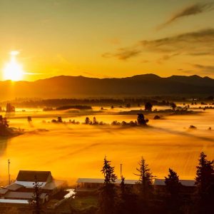 Fog on the ground in Enumclaw with a pastel-colored sunrise viewed from the sky in a hot air balloon
