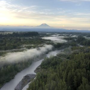 Morning hot air balloon ride over the White River with a view of Mt. Rainier. Beautiful pine trees fill the river canyon.