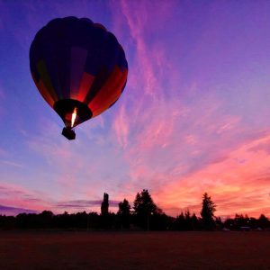 Pink and purple sunrise with a hot air balloon launching