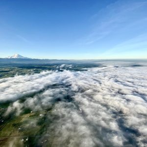 Fog on the ground lit up by the sunrise in front of Mt. Rainier. 2000 feet in the air in a hot air balloon