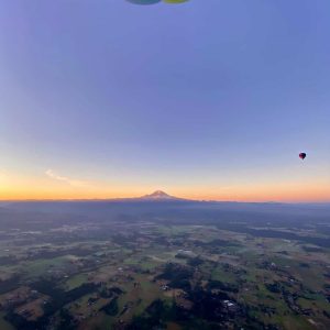Hot air balloon at 3000 feet at sunrise looking out at Mt. Rainier while flying over the White River in Enumclaw, WA