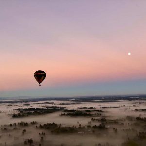 Hot air balloon flying at sunrise South of Seattle with a pink, purple, and blue sky