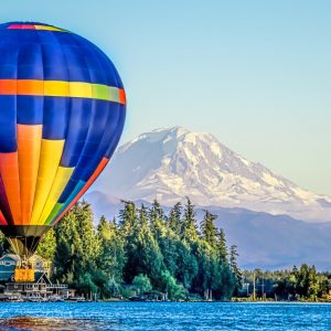 Hot air balloon flying low over Lake Tapps with an epic view of Mount Rainier